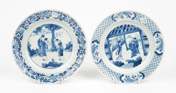 A Chinese blue and white plate in Kangxi style, painted with a central figurative panel inside a diaper border reserved with flower panels, 22.5cm dia