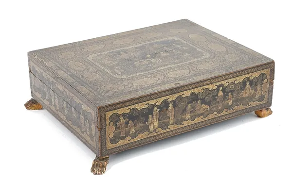 A Chinese export gilt and black lacquer games box, early 19th century, of rectangular form raised on four paw feet, the cover gilt and painted with a