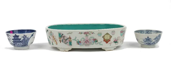 A Chinese famille-rose planter, 19th century, of oblong form raised on four bracket supports, the exterior painted with Buddhist symbols, the interior