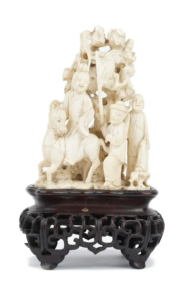 A Chinese ivory group, late 19th/early 20th century, carved with a woman on horseback with two attendants, before pierced rockwork and trees, 17cm hig