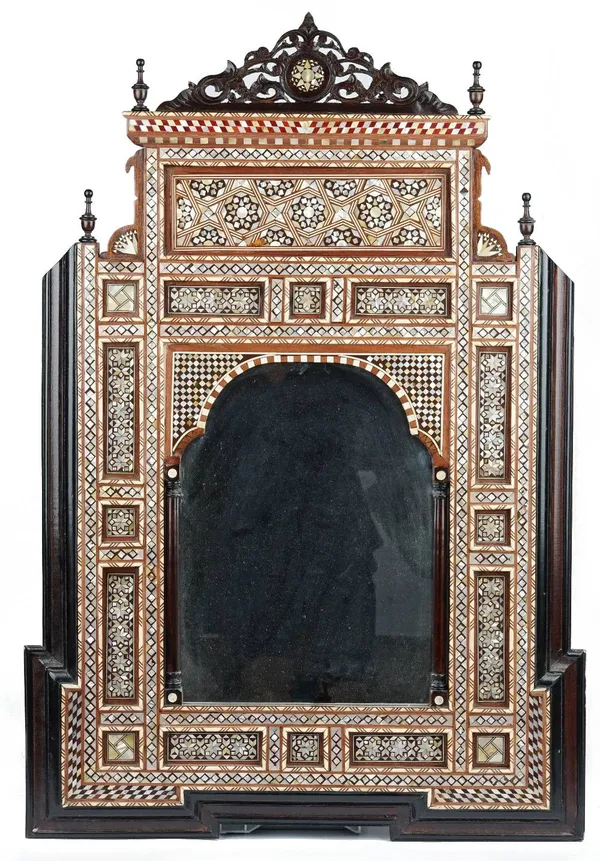 An Ottoman style architectural wood mirror, 20th century, inlaid with mother-of-pearl geometric patterns, carved and pierced wood surmount, 97cm x 66c