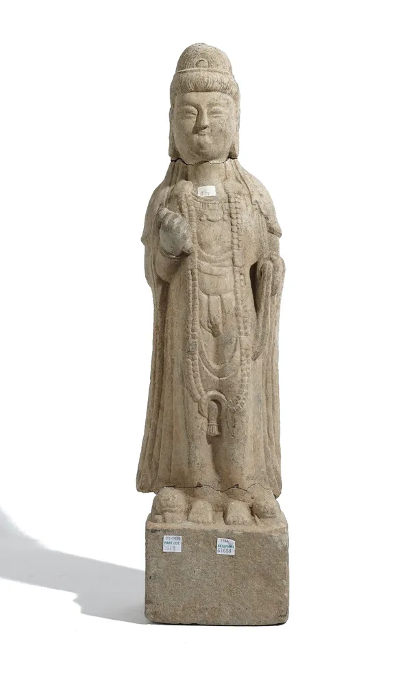 A tall Chinese stone figure of Buddha, standing in long robes on a rectangular plinth flanked by two recumbent lions and incised with inscriptions, (a