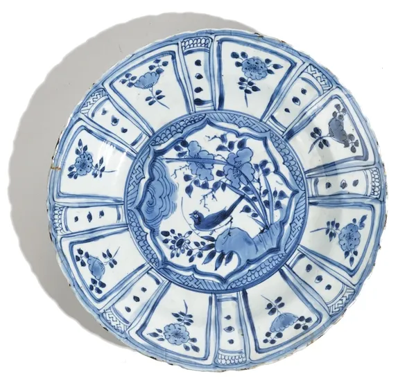 A Chinese kraak porcelain blue and white dish, early 17th century, painted in the centre with a bird perched on a rock, inside a panelled border enclo