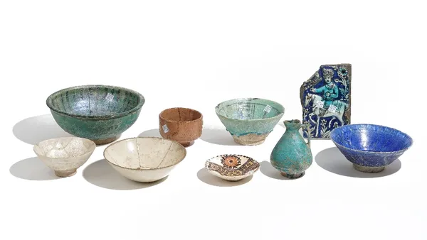 A group of Islamic pottery, circa 12th century and later, comprising; a turquoise glazed jug, 13.5cm high; two turquoise bowls with underglaze-black d