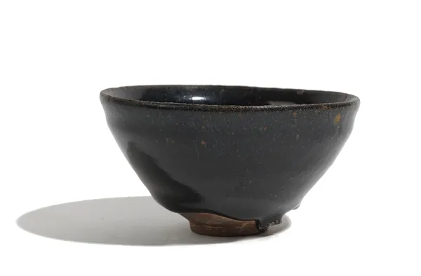 A Chinese brown glazed teabowl, Song dynasty or later, covered in a dark brown glaze with lighter brown specks, 11.5cm wide, boxed.