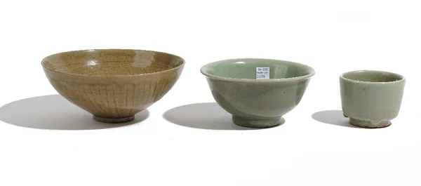 A Chinese celadon bowl, the interior incised with foliate scrolls beneath an olive green glaze, 19cm diameter; another celadon glazed bowl, 15cm diame