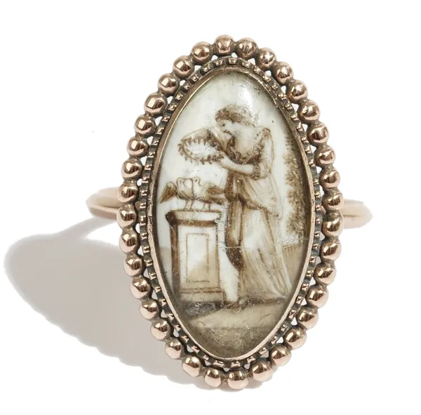 A gold mourning ring, circa 1800, glazed with a sepia miniature of a standing woman holding a wreath above two birds on a pedestal, within a beaded su