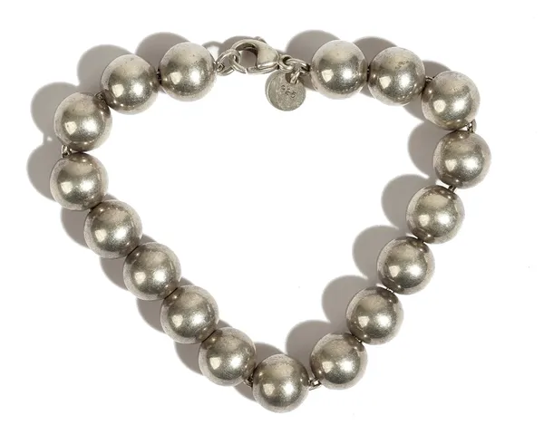 A Tiffany & Co silver bracelet, formed as a row of spherical beads, on a sprung hook shaped clasp, length 18.5cm, gross weight 17.8 gms, with an assoc