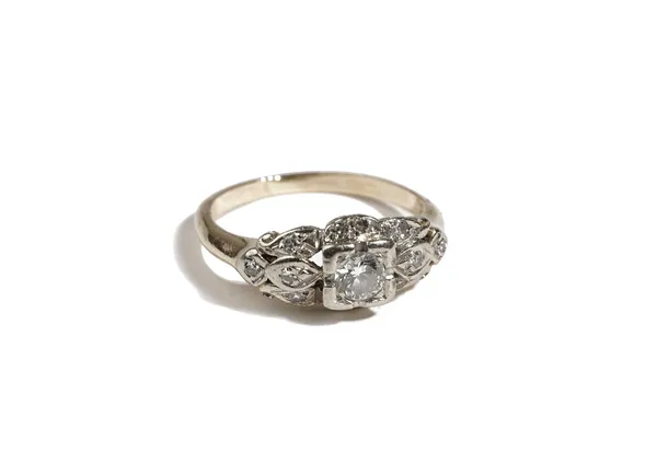 A gold and diamond ring, mounted with the principal circular cut diamond at the centre, otherwise in a tapered and pierced design, set with smaller ci