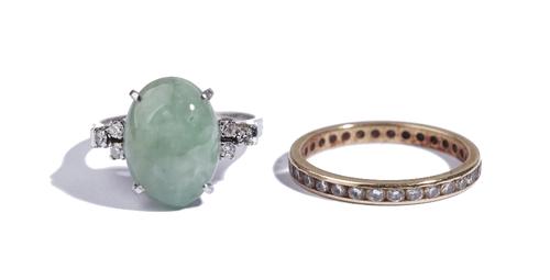 A white gold, jade and diamond ring, claw set with the oval cabochon jade between circular cut diamond set three stone shoulders, detailed 585, 14 K,
