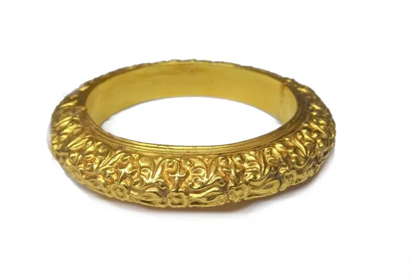 An Asian gold bangle, of circular hinged hollow form, with scrolling decoration, internal diameter 5.8cm, gross weight 20 gms.