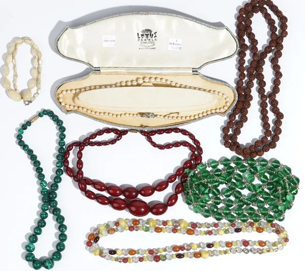 A single row necklace of graduated cultured pearls, on a paste set clasp, with an associated case, a single row necklace of graduated malachite beads