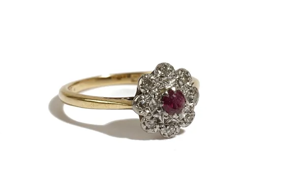 An 18ct gold ring, claw set with a circular cut ruby in a surround of eight circular cut diamonds, Birmingham 1962, ring size N, gross weight 3.1 gms.