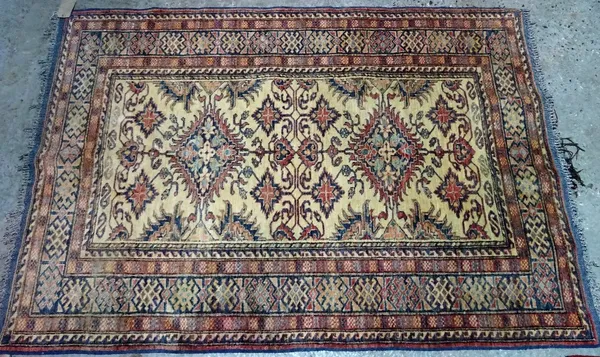 A Shirvan rug, caucasian, the ivory field with two diamonds, other motifs, an indigo hooked motif border, 183cm x 130cm.