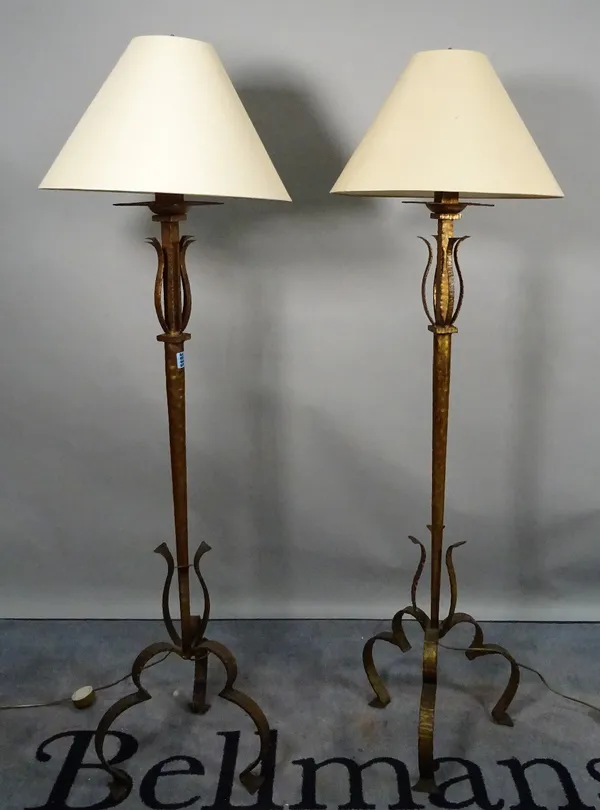 A modern pair of gold painted metal standard lamps, on scrolling supports and shades, 153cm high. (2)