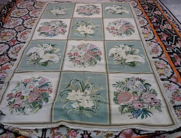 A Portuguese chain stitch needlework carpet with three x four panels in alternating green and ivory, each with a floral bouquet, with fringe around ed