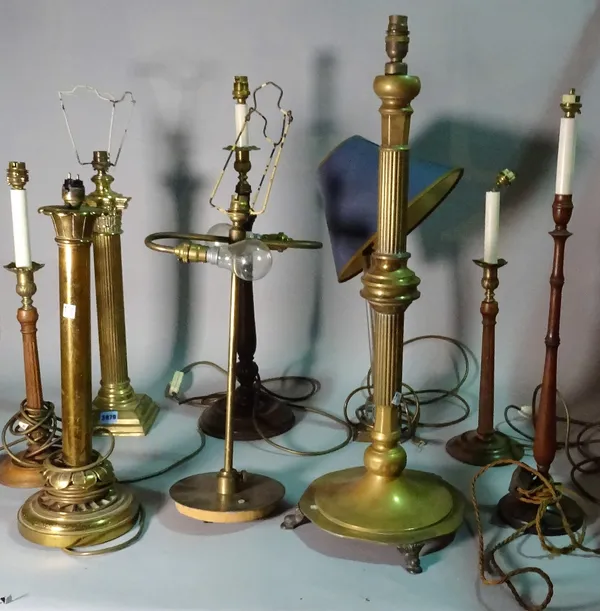 A group of eight 19th century and later table lamps, including brass, wooden and glass examples, the tallest 71cm. (8)