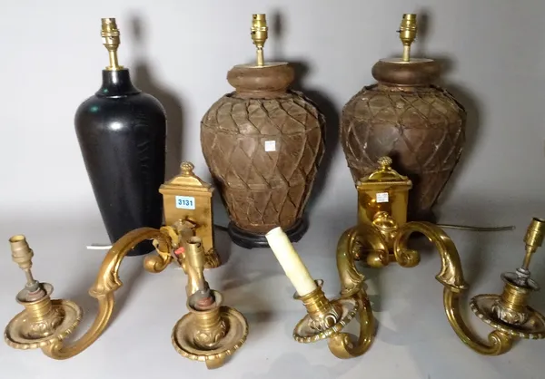 A pair of early 20th century brass two branch wall lights, 32cm wide, a modern ebonised lamp, 44cm high, and a pair of modern composite metal lamps, 4