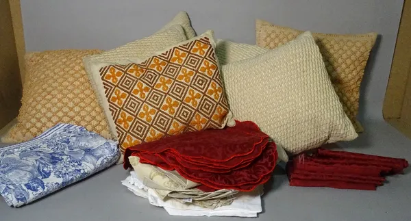 A group of assorted cushions and a bag of fabric and napkins.