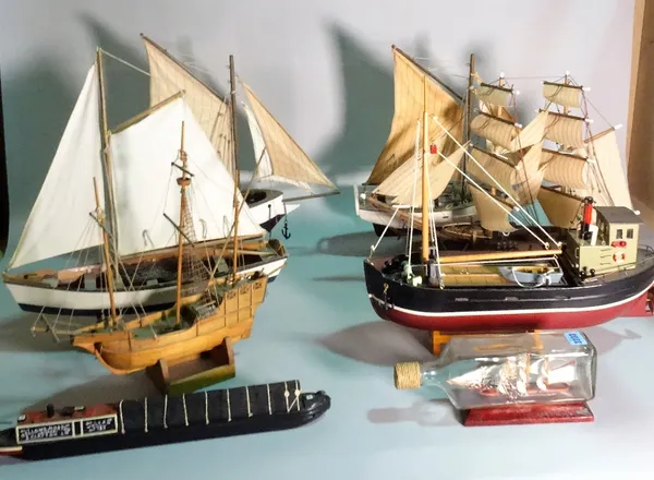 A group of eight modern wooden models of boats and sailing ships, including one within a glass bottle, the largest 45cm wide x 56cm high. (8)