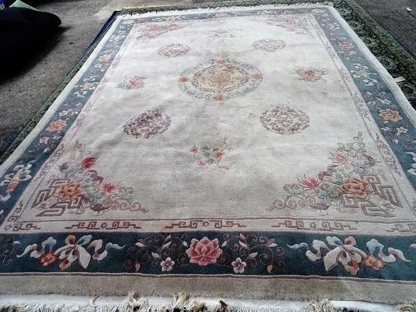 A Chinese carpet with beige field and floral roundels, 375cm x 280cm.