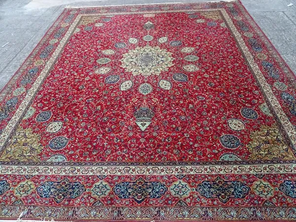 A Wilton carpet, machine made of Persian design, the red field with central medallion, 322cm x 276cm.