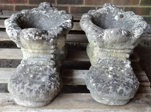 A pair of modern reconstituted stone planters, formed as boots, each 45cm wide x 26cm high.