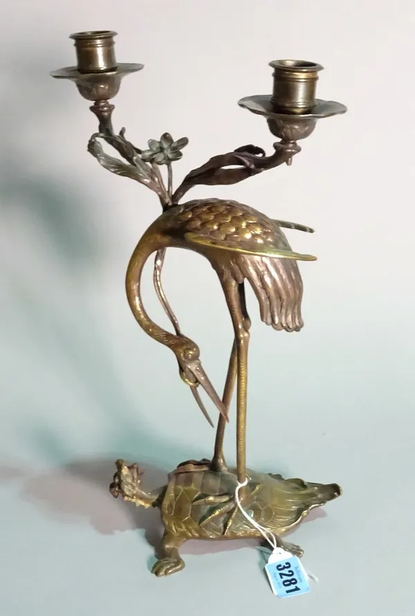 A Chinese bronze twin branch candelabra, modelled as a heron on a beast, 35cm high.