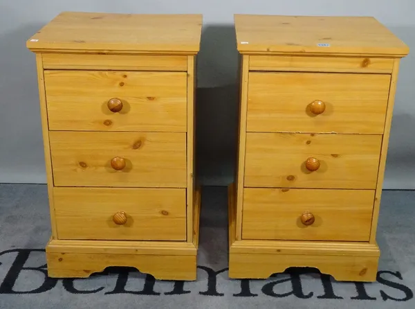 A pair of modern pine bedside chests, with three short drawers, 44cm wide x 74cm high. (2)