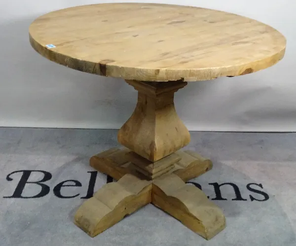 A modern pine circular dining table, on tapering column and X-frame base, 100cm diameter x 81cm high.