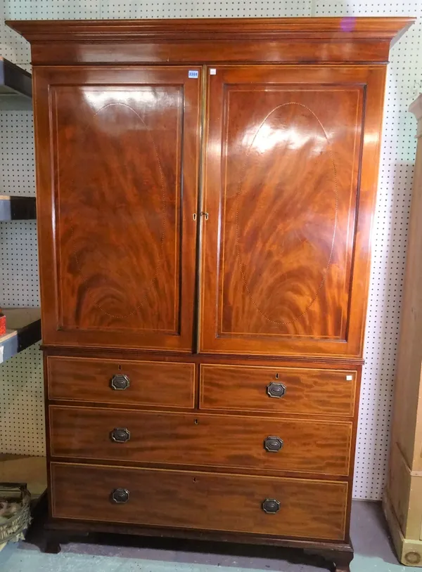 A George III style inlaid mahogany linen press, with cupboard doors over two short and two long drawers on bracket feet, 135cm wide x 202cm high.