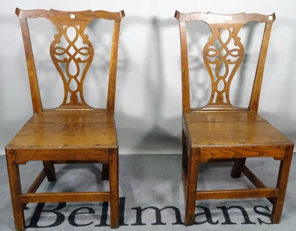 A pair of 18th century oak pierced splat back chairs, 49cm wide x 95cm high, together with another similar.