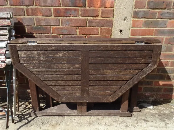 A modern hardwood drop flap garden table, 120cm wide x 73cm high.