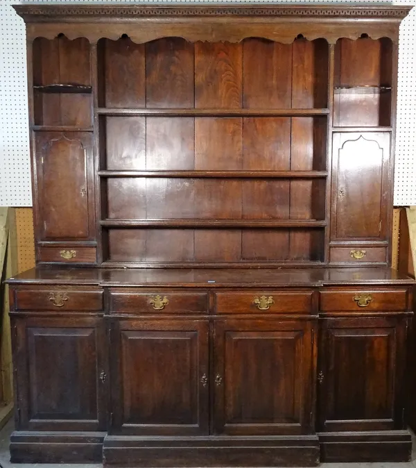 A mid-20th century oak dresser, with three tier plate rack flanked by cupboards, 198cm wide x 246cm high.