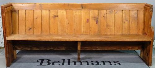 An early 20th century pine pew, 212cm wide x 89cm high.