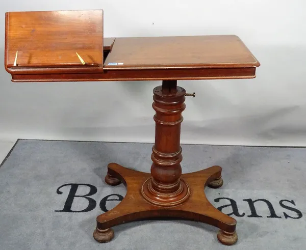 A Victorian mahogany height adjustable reading table, on turned column and quatrefoil base on bun feet, 91cm wide x 87cm high.
