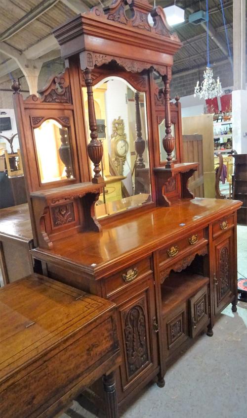 A late Edwardian mahogany sideboard, the mirrored back over carved panel doors on turned supports, 150cm wide x 245cm high.