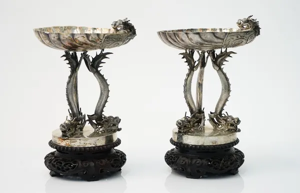 A pair of Chinese sweetmeat stands, each formed as a scallop shell with a dragon's head to the side, raised on three dragon supports, on a plain circu