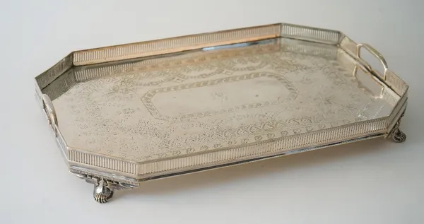 A Victorian silver plated twin handled gallery tray with engraved decoration, raised on four foliate capped feet, 52cm long x 34.5cm wide.