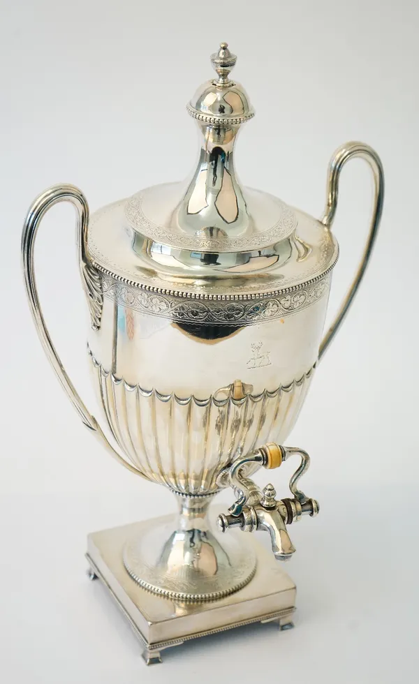 A Victorian silver twin handled hot water lidded urn, of Adam form, the body with partly fluted decoration, engraved with a foliate band and a crest,