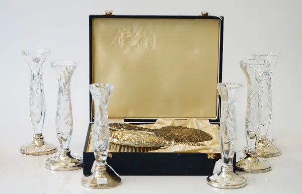 A lady's silver mounted hairbrush and mirror set, with embossed decoration, with a fitted case and six faceted glass bud vases, each raised on a silve