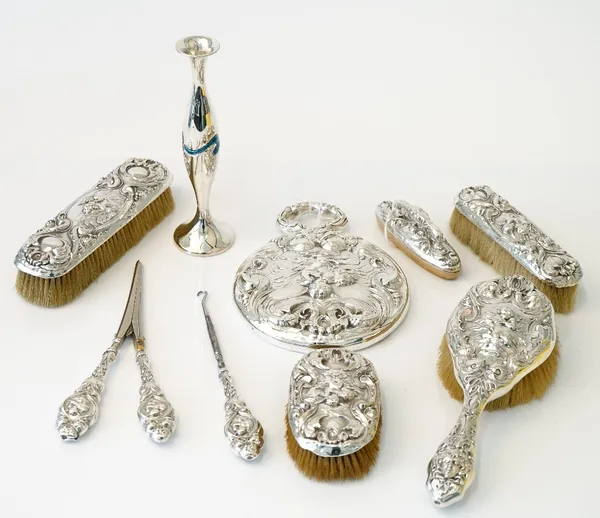 A Sterling silver mounted lady's eight piece dressing set, comprising; a hand mirror, a hairbrush, a small oval hairbrush, a large clothes brush, a sm