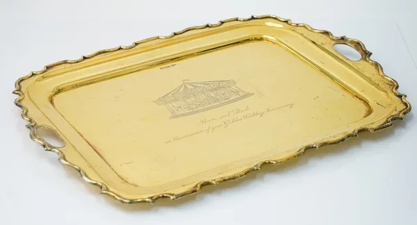 A silver gilt shaped rectangular twin handled tray, the centre presentation inscribed and engraved with a merry-go-round scene, by Walker & Hall, Shef