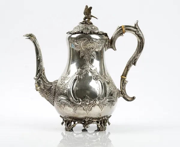 A late Victorian Irish silver coffee pot, of baluster form with floral, foliate and scroll embossed decoration, the spout with a bird's head motif, th