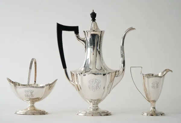 An American Sterling silver three piece coffee set, comprising; a coffee pot having black fittings, a sugar bowl with a swingover handle and a milk ju