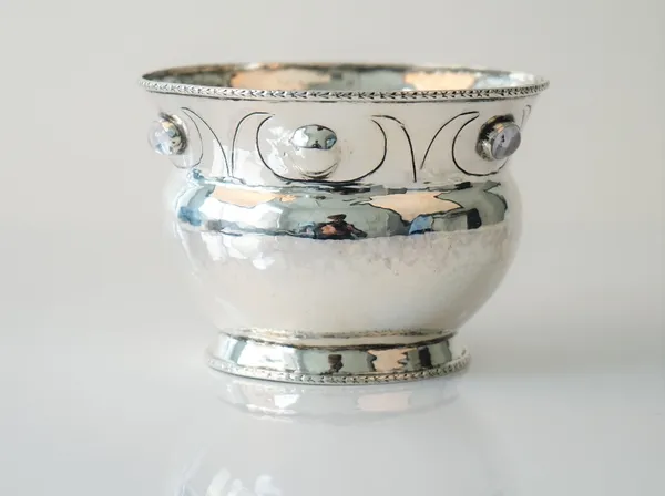 A silver vase in an Arts & Craft's design, mounted with three oval cabochon rock crystals below a decorated rim, height 7.5cm, gross weight 139 gms, m