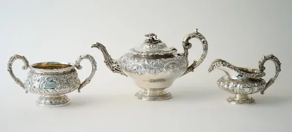 A group of silver tea wares, comprising; a teapot of squat circular form, with floral and scroll embossed decoration, having a foliate capped handle a