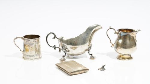 Silver, comprising; a sauceboat, with a scrolled handle (one of the three feet detached, but present), London 1924, a rectangular cigarette case with