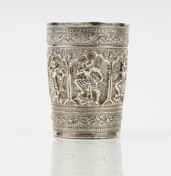 An Asian beaker, of tapered cylindrical form, decorated with a central band of dancing figures within wide scroll decorated borders, probably Indian o