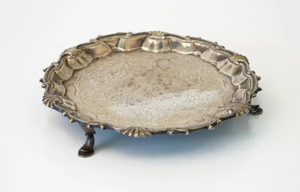 A George II silver salver, of shaped circular form, decorated with a scrolled rim, with scallop motifs in the Chippendale style, otherwise with later